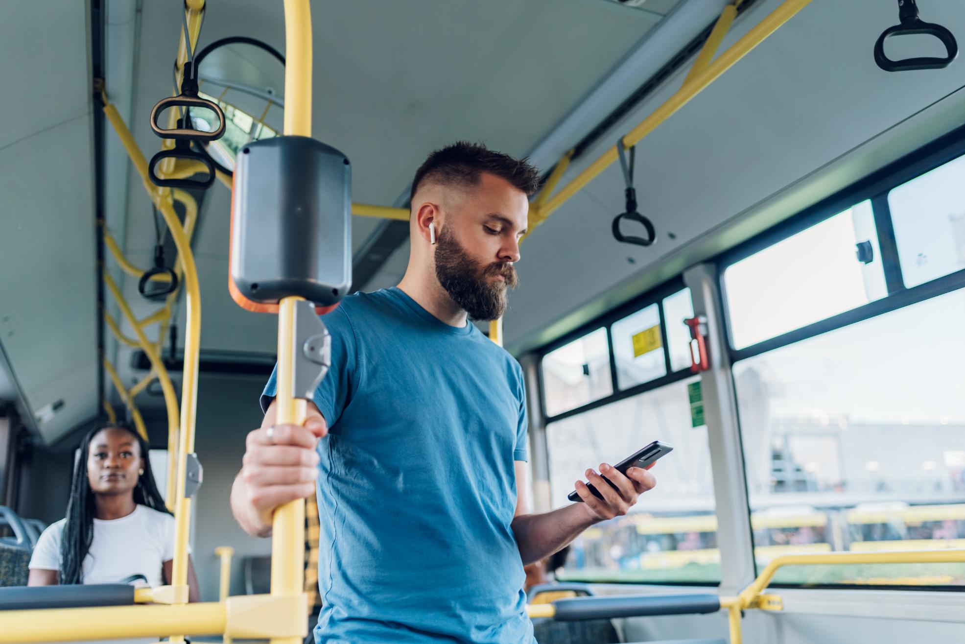 man-using-smartpone-while-riding-in-a-bus