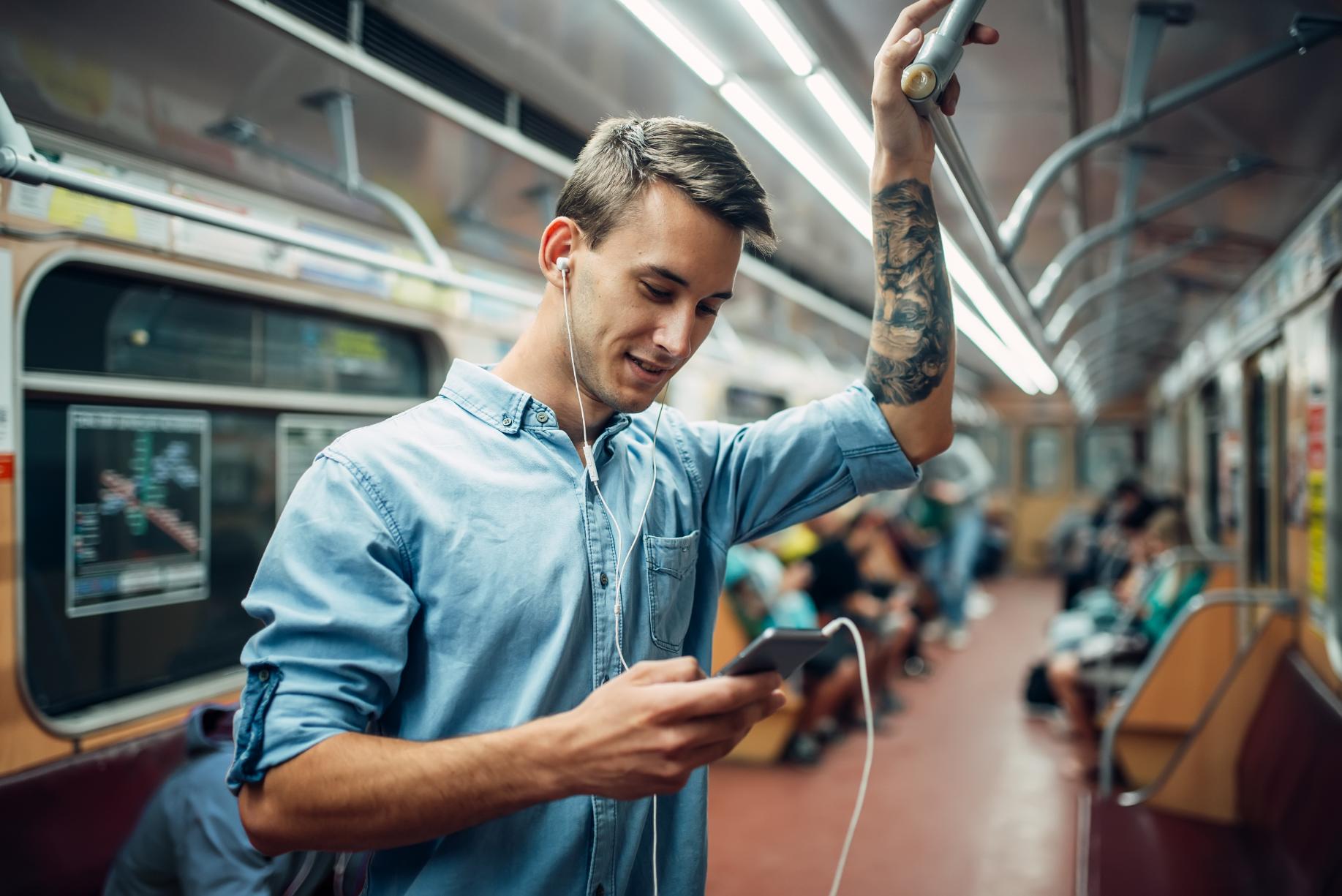 young-man-using-phone-in-metro
